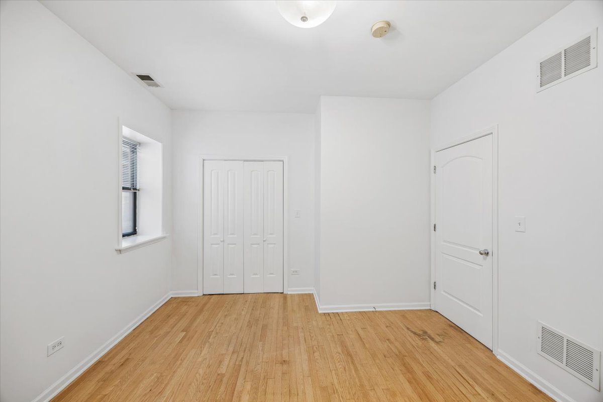 2363 East 70th Street, Unit 1 Chicago, IL 60649 - Photo 11 of 26 a view of a room with wooden floor and white walls
