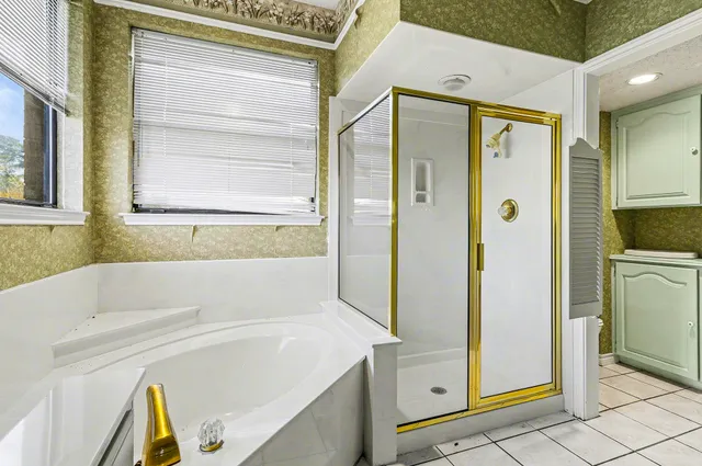 a spacious bathroom with a double vanity sink mirror and bathtub