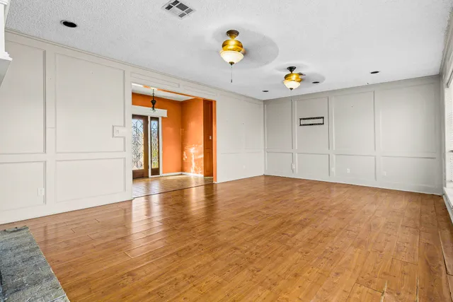 wooden floor fireplace and windows in an empty room