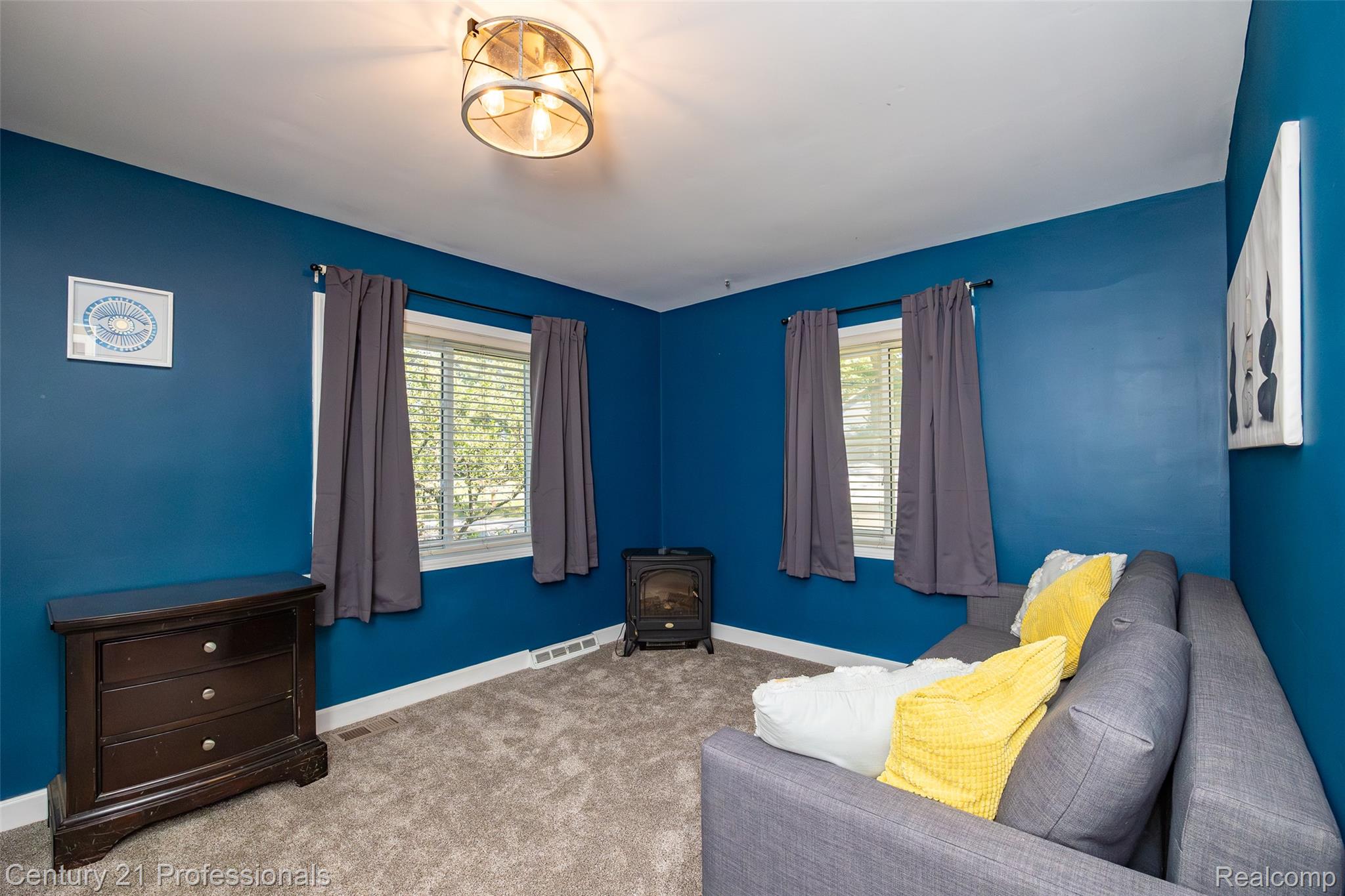 3251 Mann Road Clarkston, MI 48346 - Photo 29 of 40 Room featuring vibrant blue walls, gray carpet, and two windows with blinds