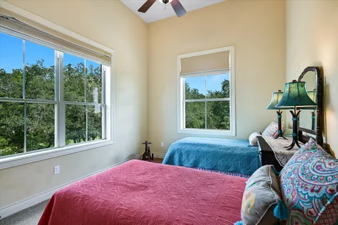 a bedroom with a bed window and table in it