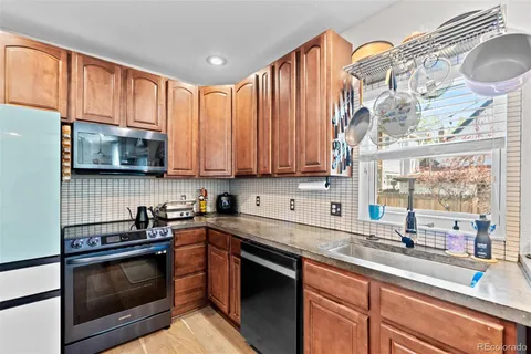 a kitchen with stainless steel appliances granite countertop a stove a sink and a microwave