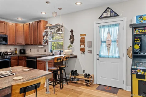 a kitchen with stainless steel appliances granite countertop a stove top oven a refrigerator a sink and a dining table with the view