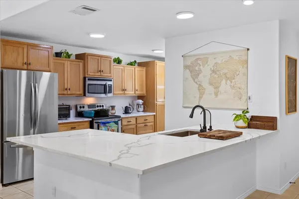 a kitchen with stainless steel appliances a sink refrigerator and a cabinets