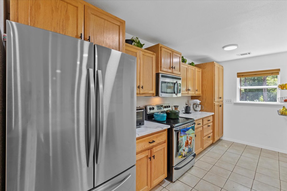 120 Lake Point Way Bastrop, TX 78602 - Photo 16 of 40 a kitchen with stainless steel appliances granite countertop a refrigerator and a sink