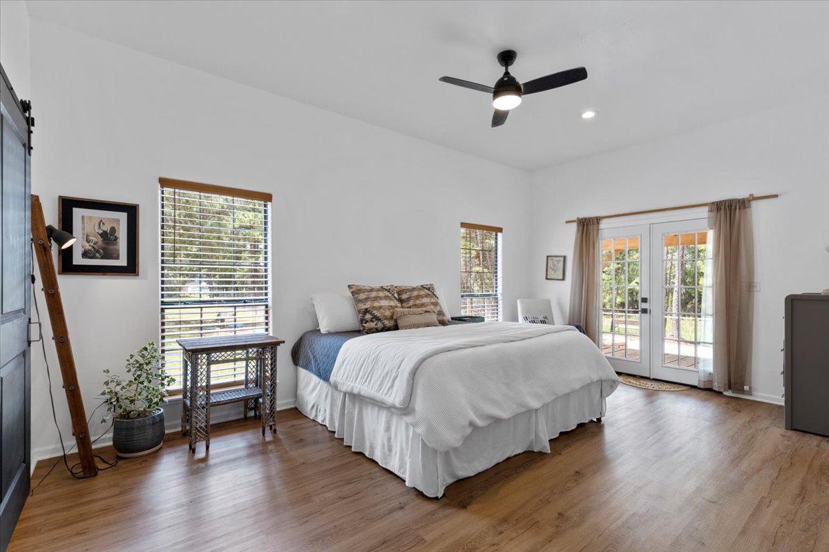 120 Lake Point Way Bastrop, TX 78602 - Photo 18 of 40 a bedroom with a large bed wooden floor and windows