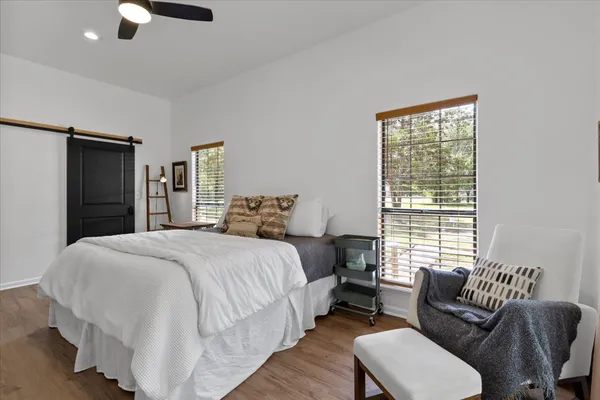 a bedroom with a large bed wooden floor and windows