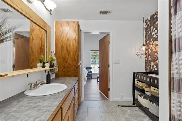 a bathroom with a granite countertop sink mirror and toilet