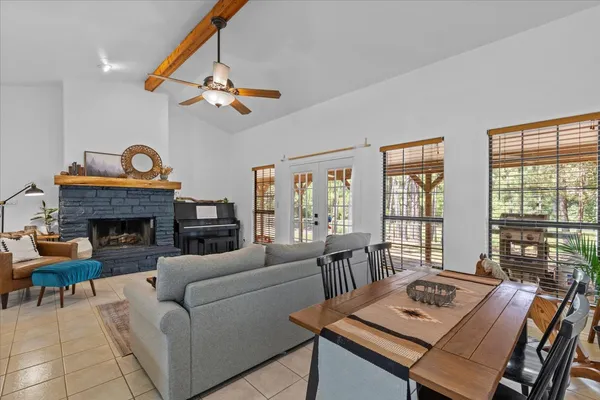 a living room with furniture a fireplace and a floor to ceiling window
