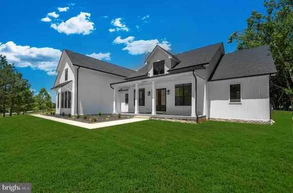 a view of a house with a yard and porch