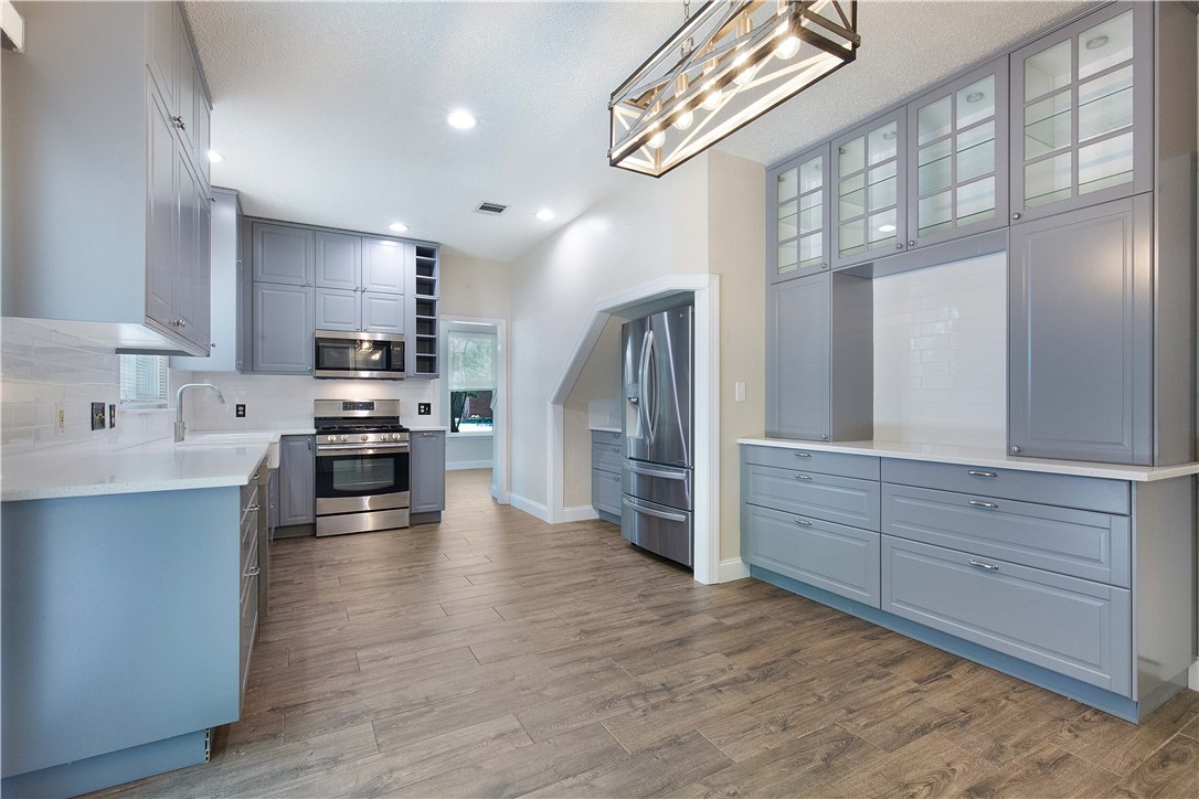 16816 Isle Of Man Road Pflugerville, TX 78660 - Photo 1 of 1 a kitchen with stainless steel appliances kitchen island granite countertop a stove a sink and a refrigerator