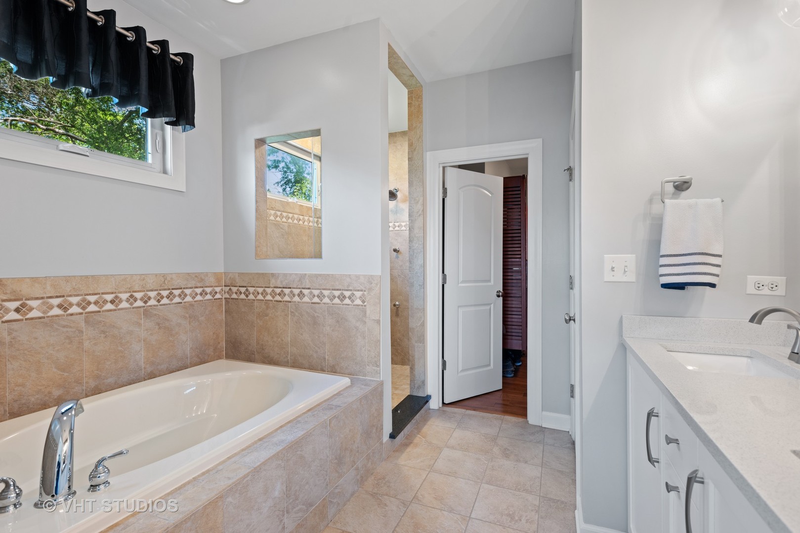 N210 Silverleaf Boulevard Wheaton, IL 60187 - Photo 26 of 48 a bathroom with a tub a sink and a window