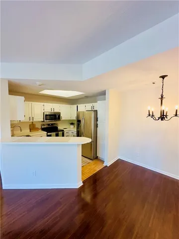 a living room with stainless steel appliances kitchen island a stove a refrigerator and a view of living room