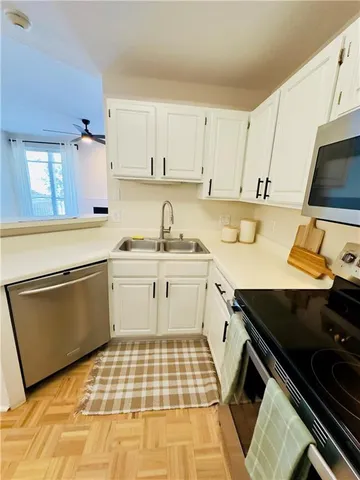 a kitchen with a sink stove and white cabinets