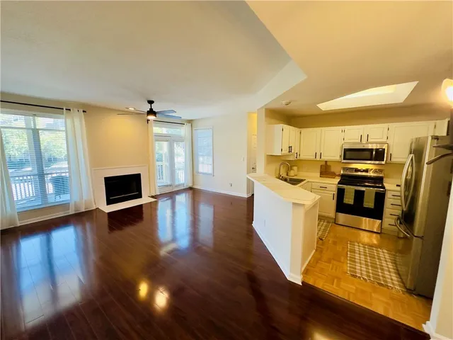 a kitchen with stainless steel appliances wooden floors and refrigerator