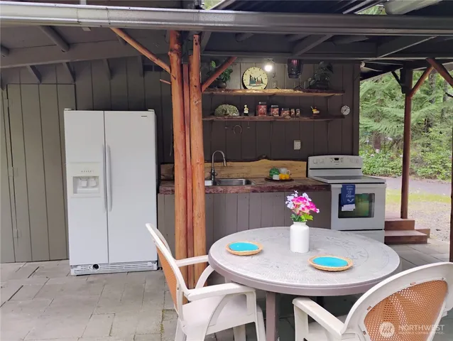 a view of outdoor dining space with a table and chairs