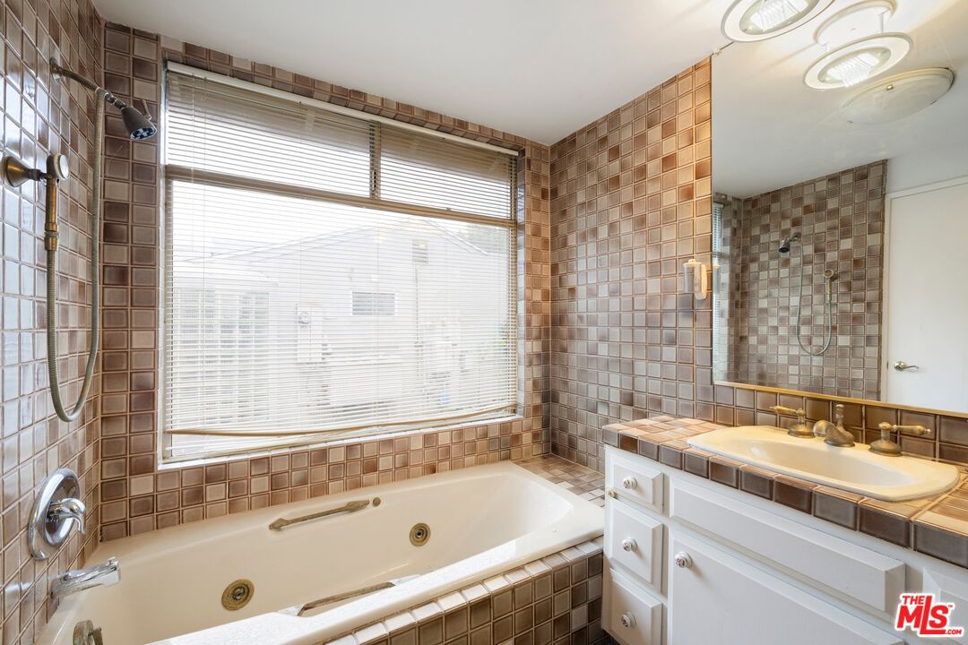 1444 Roscomare Road Los Angeles, CA 90077 - Photo 12 of 19 a bathroom with a tub sink and mirror