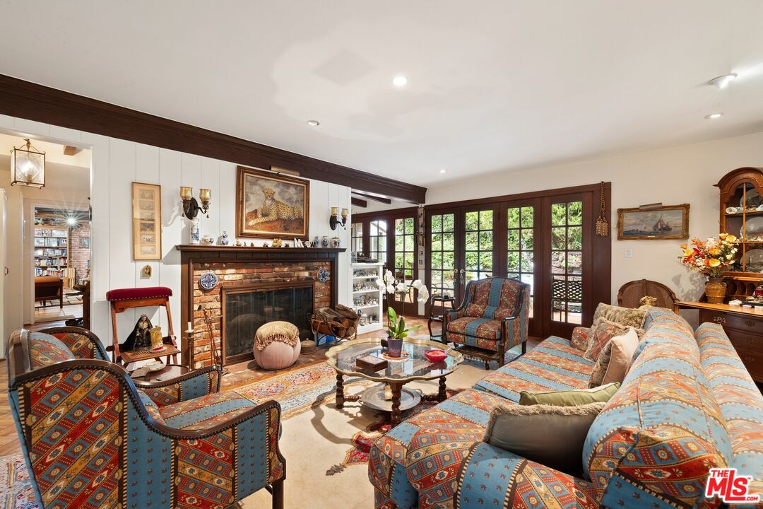 1444 Roscomare Road Los Angeles, CA 90077 - Photo 3 of 19 a living room with furniture a fireplace and a floor to ceiling window