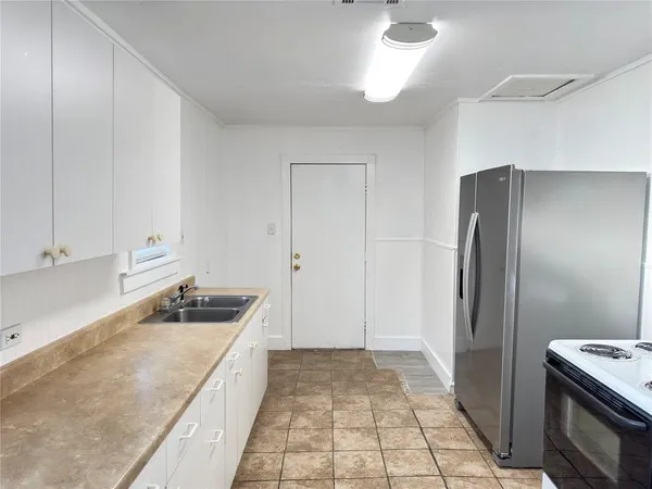 a kitchen with granite countertop a refrigerator and a sink
