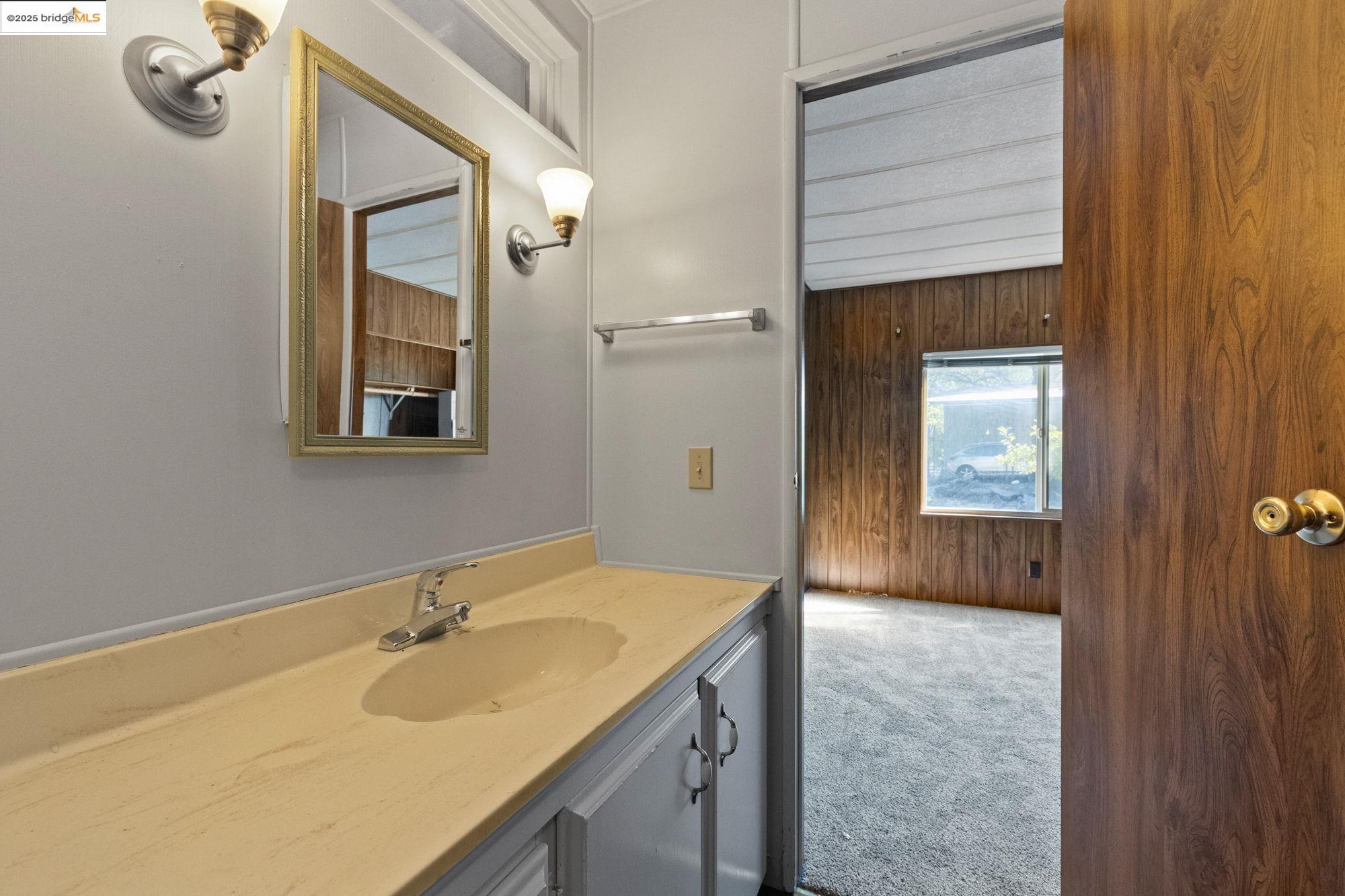 10956 Green Street, Unit 186 Columbia, CA 95310 - Photo 14 of 21 Bathroom featuring wood walls and vanity