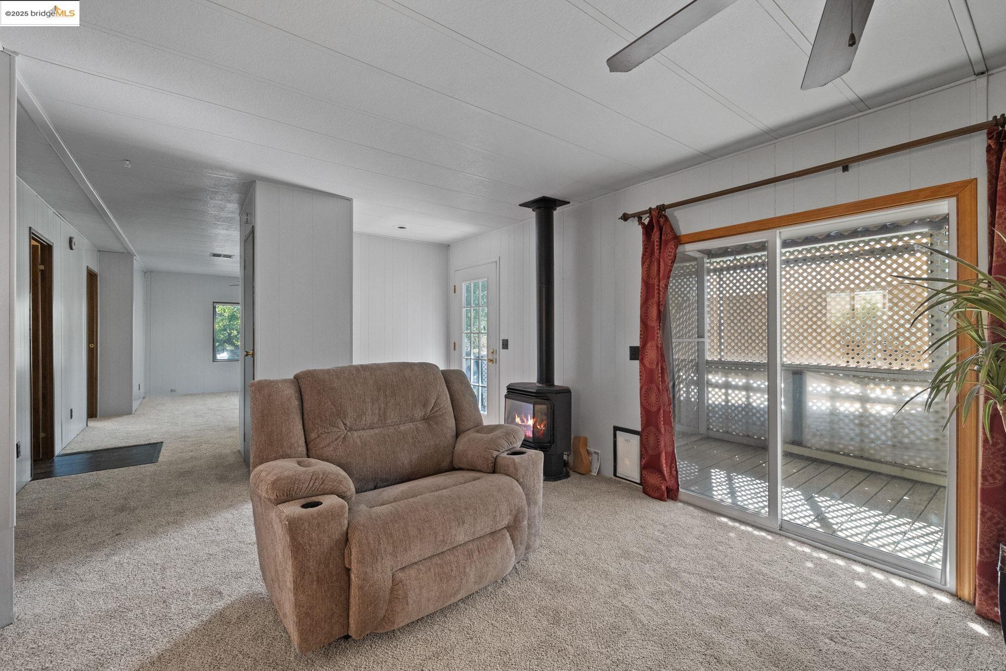 10956 Green Street, Unit 186 Columbia, CA 95310 - Photo 4 of 21 Carpeted living area with a wood stove and plenty of natural light