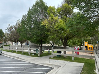 7936 Wycliffe Way Eagle Mountain, UT 84005 - Photo 36 of 37 Community playground featuring a sand surface, colorful play structures, and mature shade trees