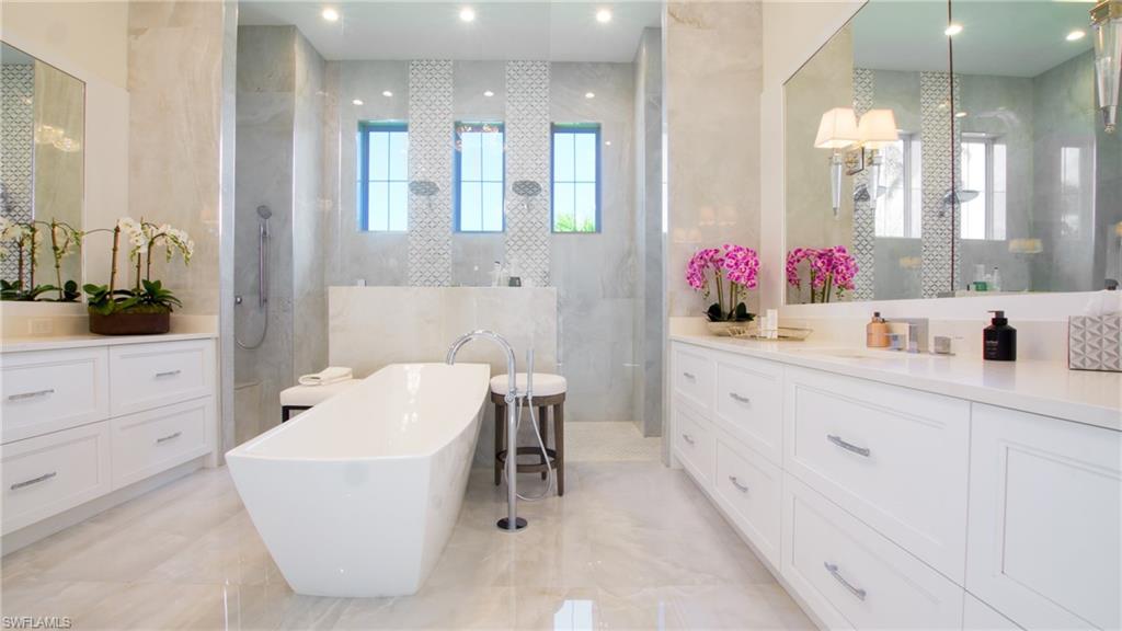 700 Wedge Drive Naples, FL 34103 - Photo 18 of 19 a bathroom with a sink mirror and a bathtub