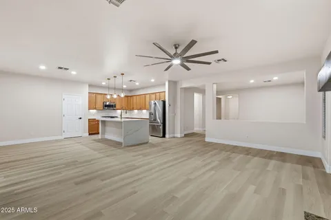 a kitchen with stainless steel appliances granite countertop a sink a stove a refrigerator and island with wooden floor