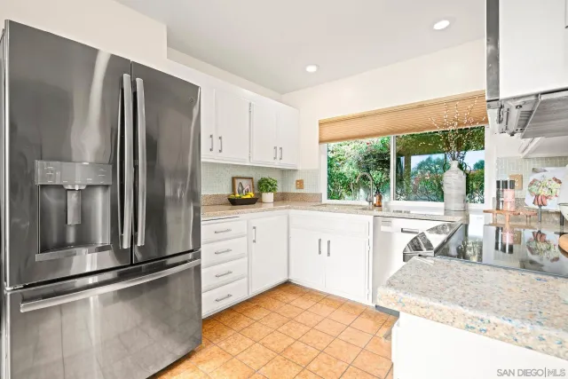 a kitchen with stainless steel appliances granite countertop a refrigerator and a stove