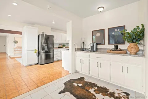 a large white kitchen with stainless steel appliances kitchen island granite countertop a refrigerator and stove