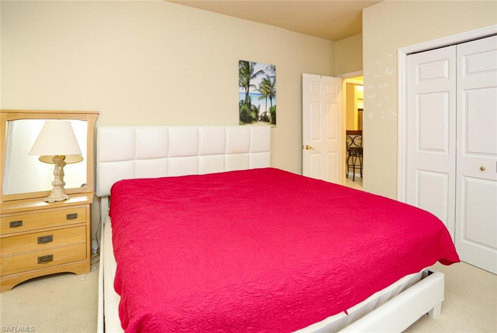 164 Spring Lake Circle Naples, FL 34119 - Photo 24 of 36 a large bed sitting in a bedroom next to a window