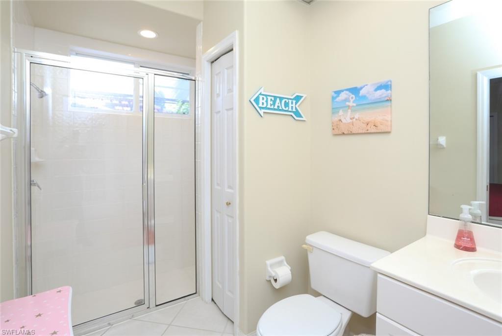 164 Spring Lake Circle Naples, FL 34119 - Photo 26 of 36 a white toilet sitting next to a bathroom sink