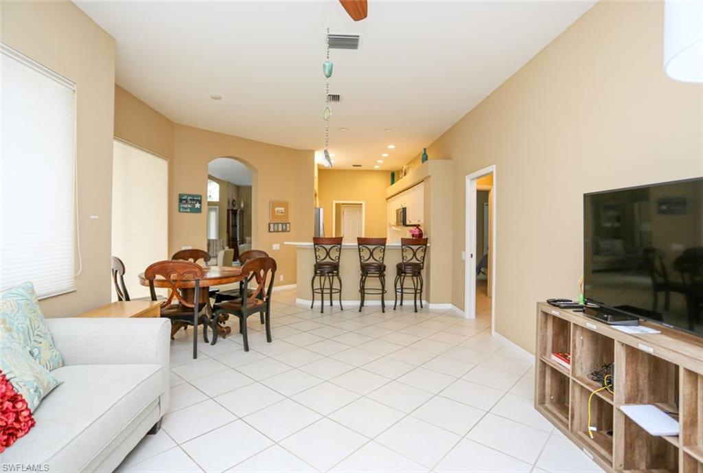 164 Spring Lake Circle Naples, FL 34119 - Photo 27 of 36 a living room with furniture and a flat screen tv