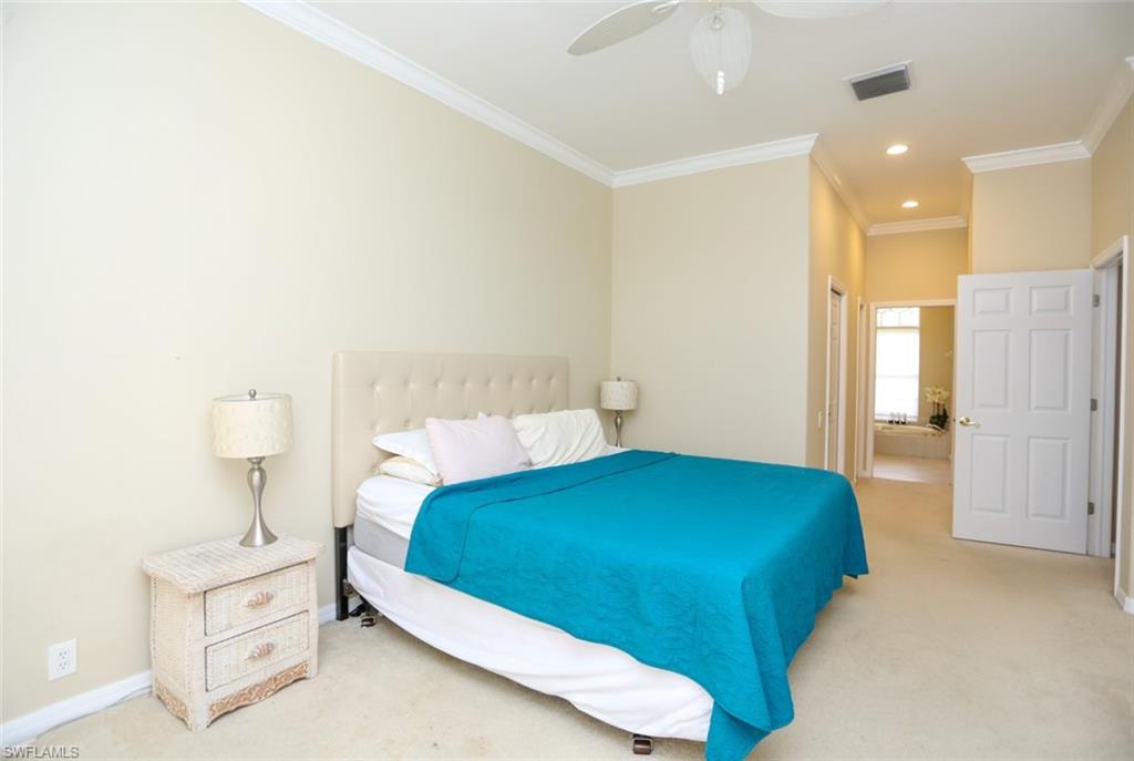 164 Spring Lake Circle Naples, FL 34119 - Photo 30 of 36 a bedroom with a bed and a night stand