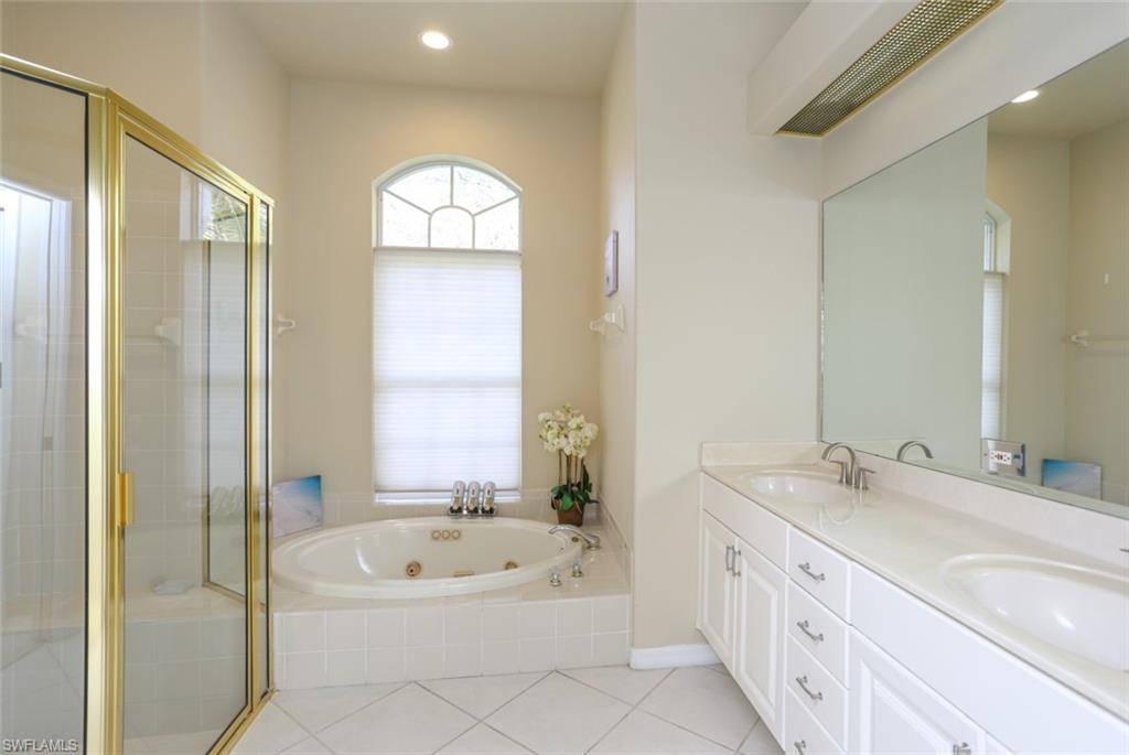 164 Spring Lake Circle Naples, FL 34119 - Photo 32 of 36 a bathroom with a double vanity sink and a bathtub