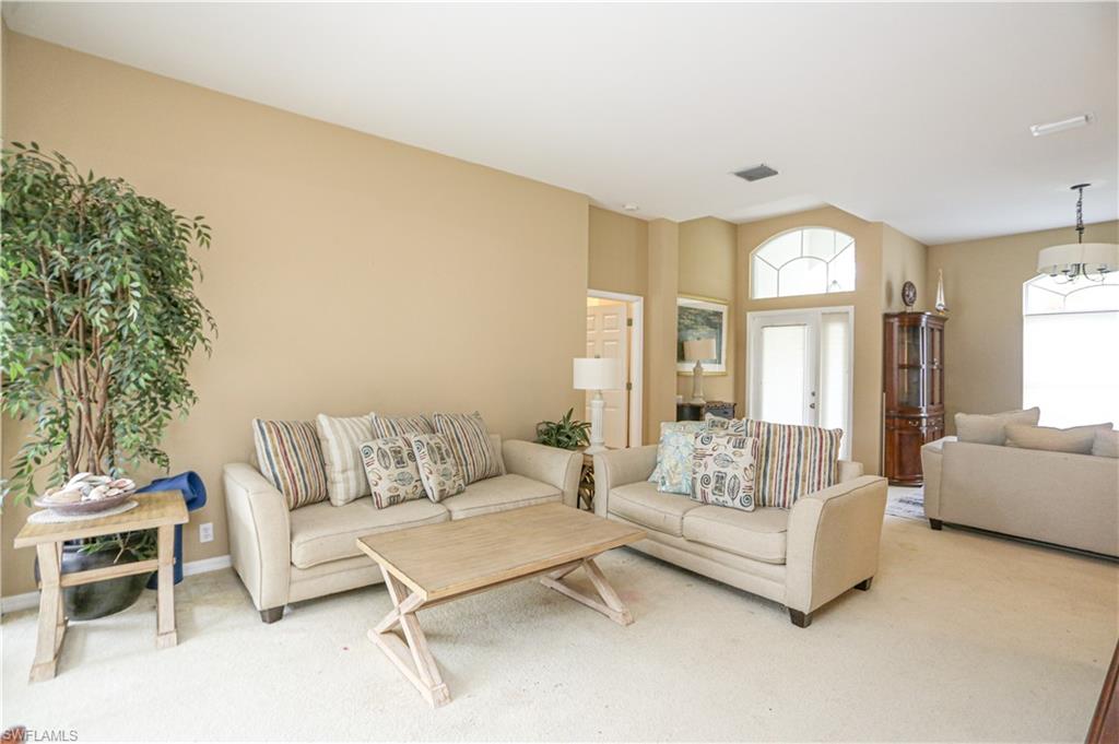 164 Spring Lake Circle Naples, FL 34119 - Photo 5 of 36 a living room with furniture and a large window