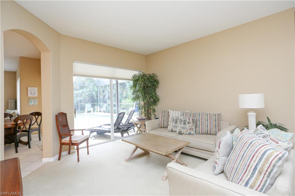 164 Spring Lake Circle Naples, FL 34119 - Photo 6 of 36 a living room with furniture and a large window