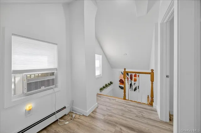 a view of a hallway with wooden floor and entryway
