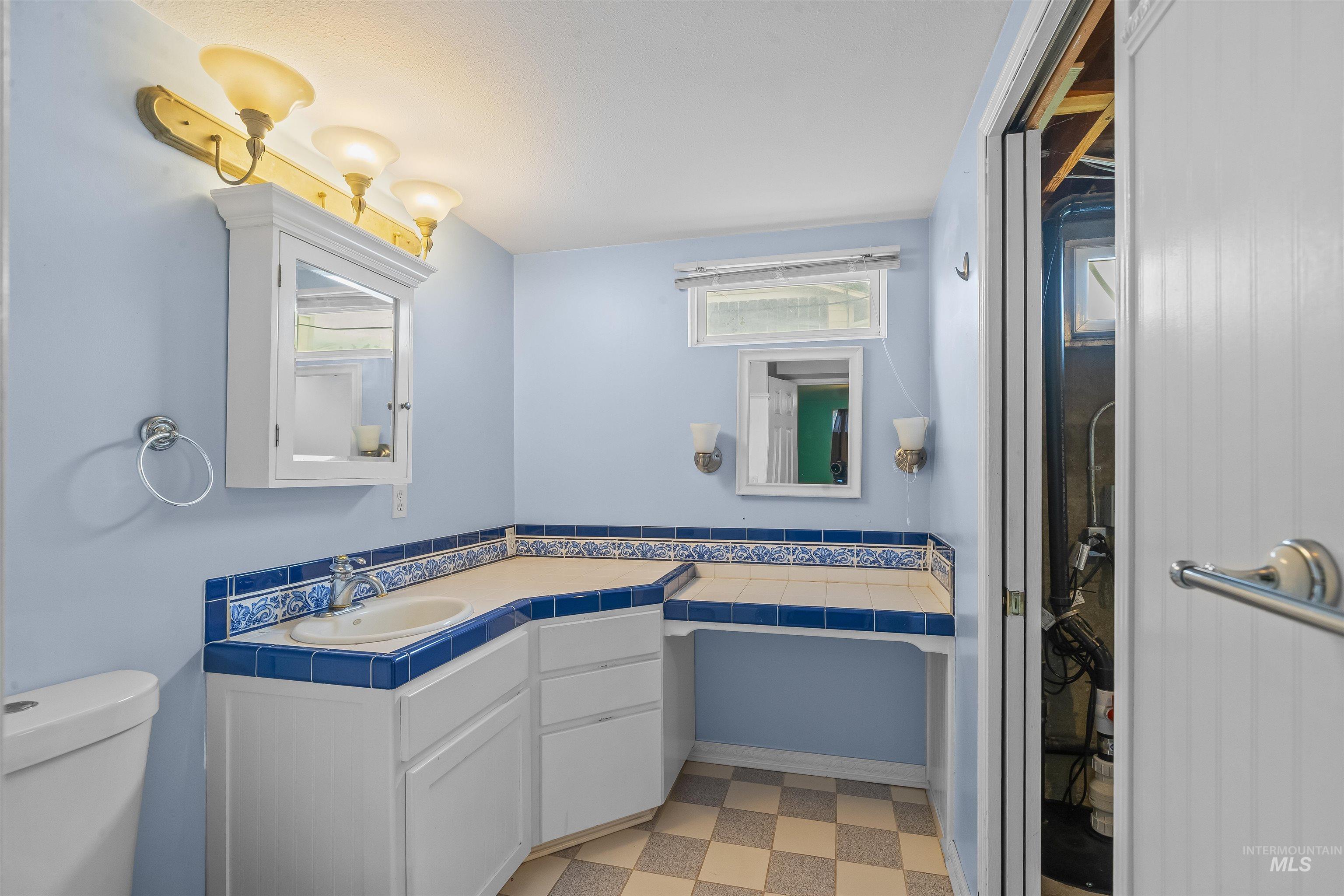 3620 18th Street Lewiston, ID 83501 - Photo 20 of 32 Bathroom vanity with integrated sink, tile countertop, and custom blue and white tiled backsplash