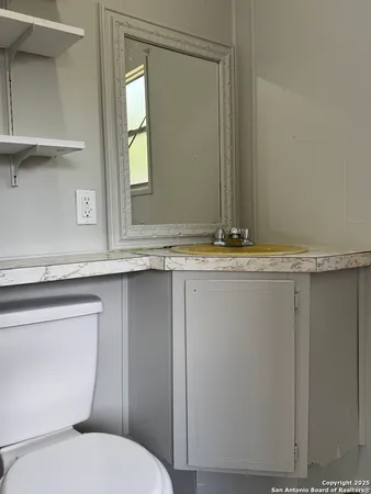 a bathroom with a toilet sink and mirror