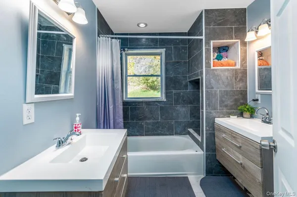 a bathroom with a tub a sink and a window