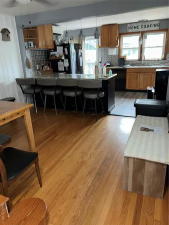 a kitchen with stainless steel appliances wooden floor a sink and a stove