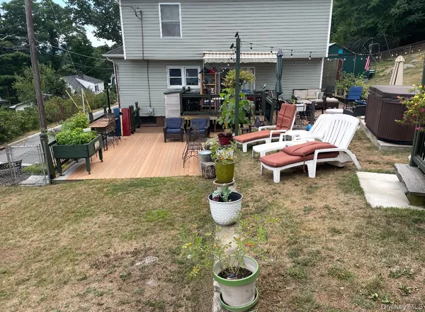 a view of a backyard with table and chairs potted plants and a fire pit