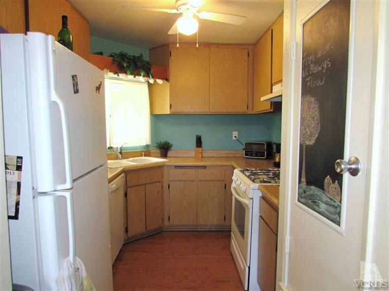 1742 Sinaloa Road, Unit 344 Simi Valley, CA 93065 - Photo 4 of 20 a kitchen with a refrigerator a sink and dishwasher with wooden floor