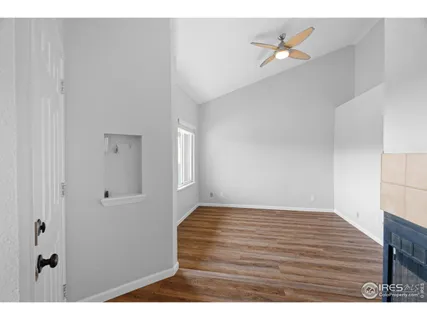 a view of an empty room with window and fire place