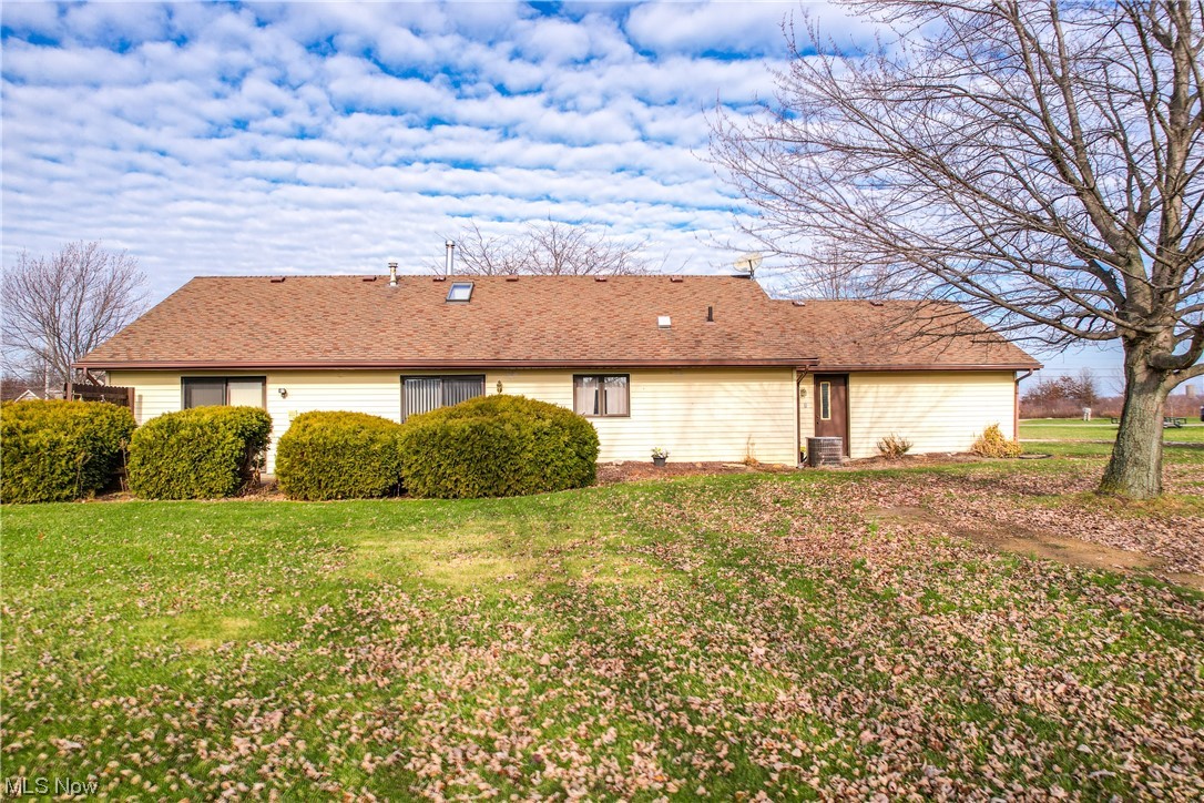 13920 Kneisel Road Vermilion, OH 44089 - Photo 5 of 35 View of side of property with a yard and central air condition unit
