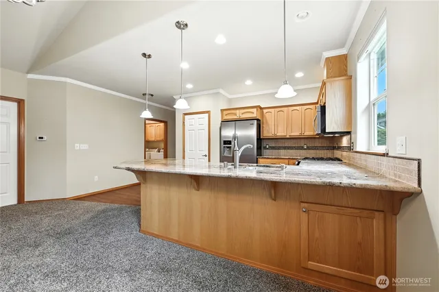 a large kitchen with granite countertop a sink and a stove