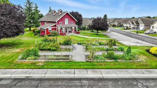 a front view of a house with a yard and potted plants