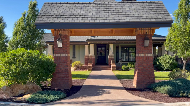 426 West Center Street Parowan, UT 84761 - Photo 2 of 107 Arched entryway featuring brick pillars, decorative outdoor lighting, and a shake shingle roofline