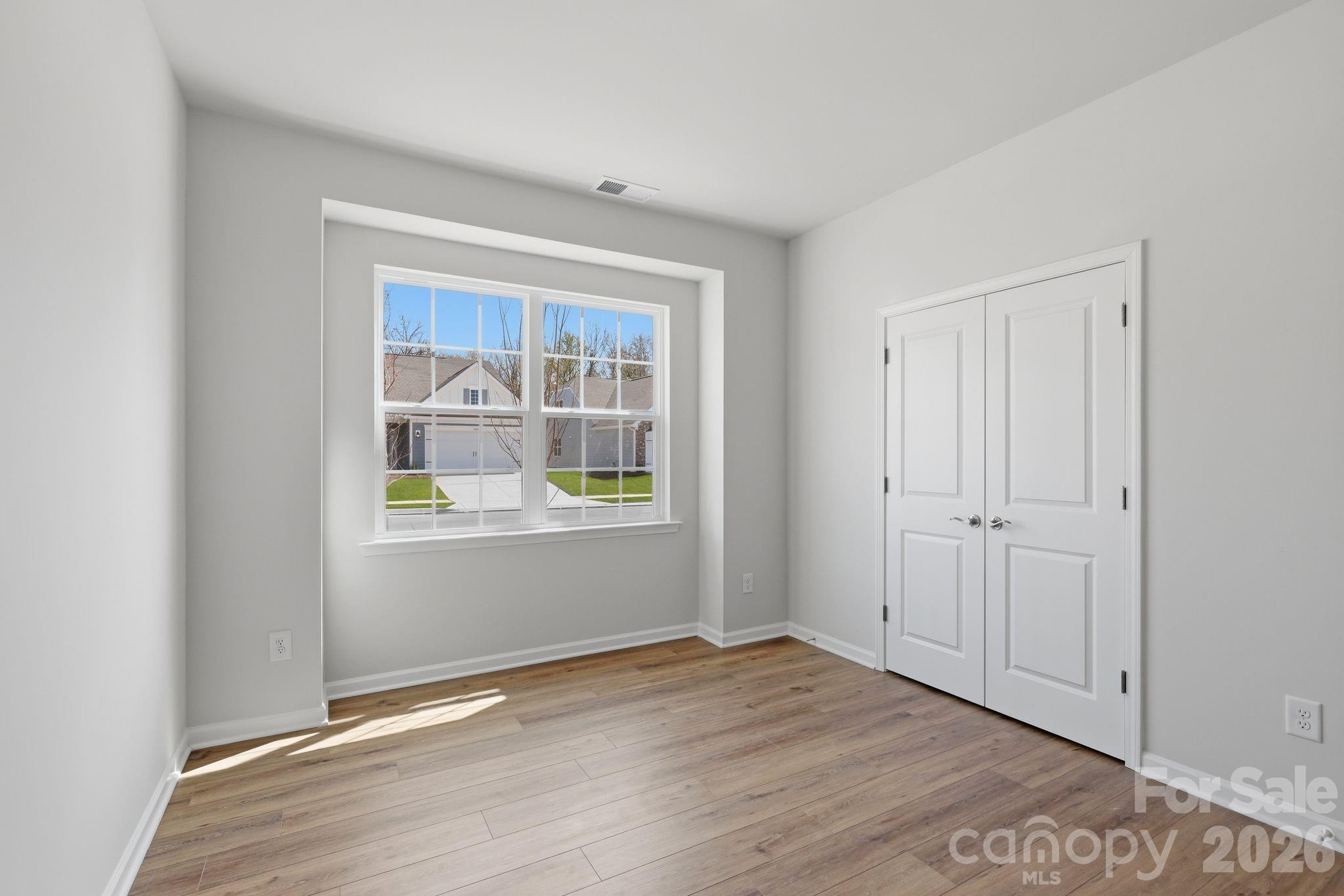 5475 Redbud Road, Unit 57 Lancaster, SC 29720 - Photo 21 of 30 a view of an empty room with wooden floor and a window